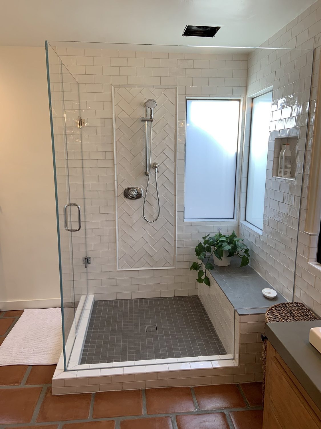Custom tile shower with herringbone accent panel
